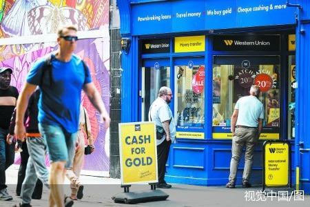 9日，英国克罗伊登，顾客在一家典当行橱窗前张望。